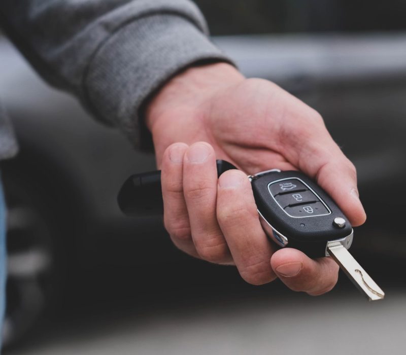 man-in-front-of-the-new-car-and-holding-keys-salesman-is-carrying-the-car-keys-delivere-e1696401738715.jpg